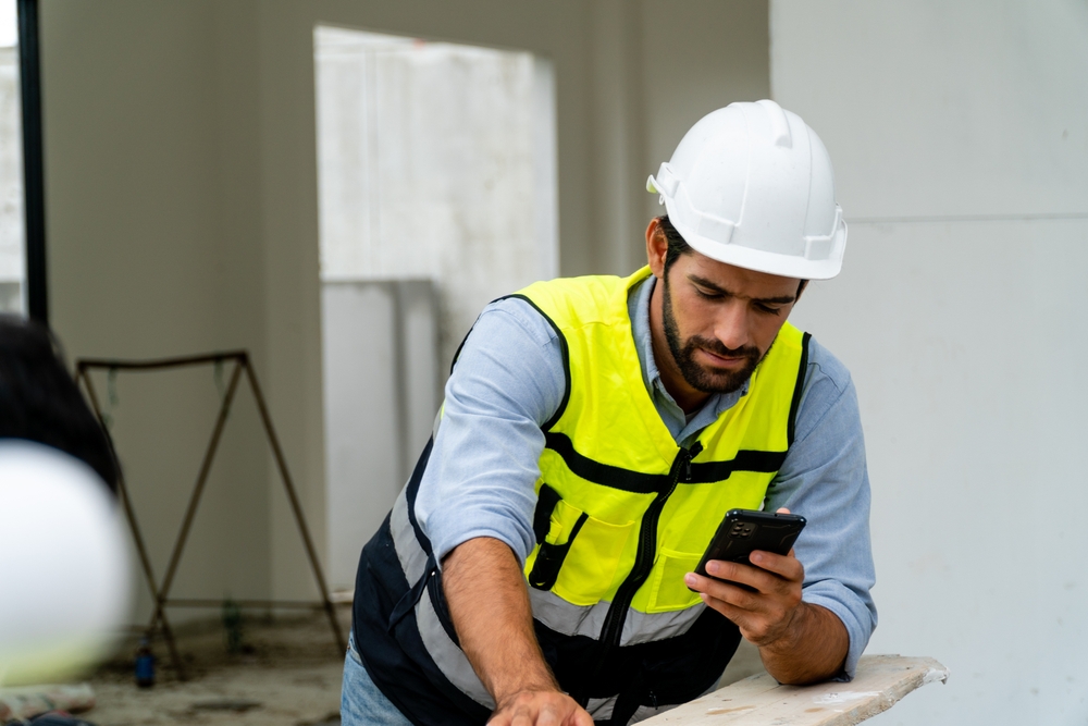 hombre casoco con celular recibiendo mensajes